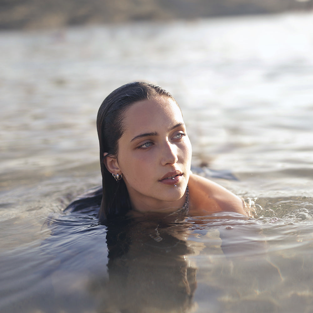 Woman swimming in the sea with piercings